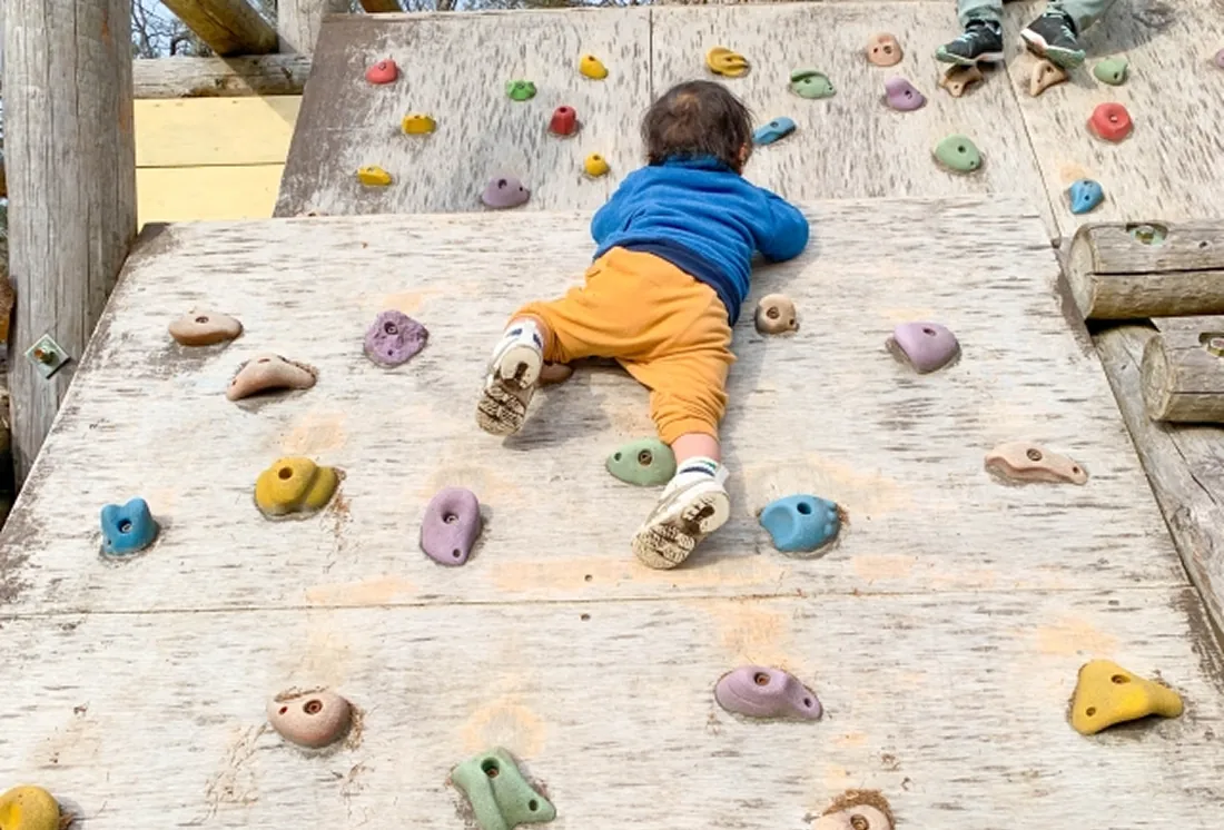 ボルダリングを登っている子どもの後ろ姿